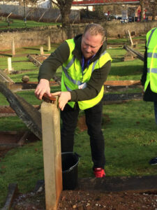 Vane Hill ARBD care home support worker cleaning war graves as part of a new 'Eyes On, Hands-On' project run by The CWGC