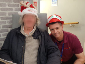 Campania ARBD care home staff and resident wearing Festive hats