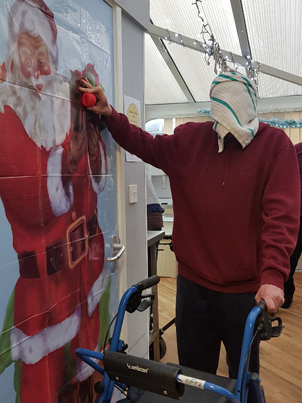 Campania ARBD care Home resident playing 'pin the nose on Santa'