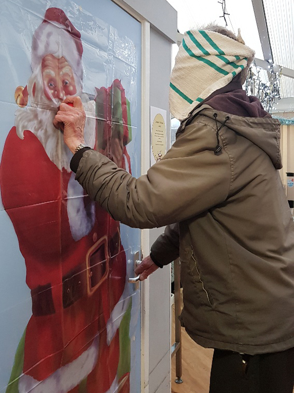 Campania ARBD care Home resident playing 'pin the nose on Santa'